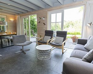 Ruime woonkamer met uitzicht op terras in Het Boshuis, Vakantiepark Het Oude Dijkje, De Koog, Texel.