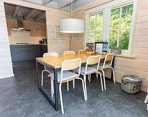 Gezellige eethoek in Het Boshuis, Vakantiepark Het Oude Dijkje, De Koog, Texel, met uitzicht op de tuin.