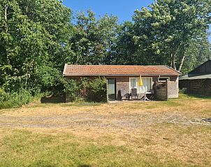 Rustieke veranda van Bungalow 0384 in De Koog, Texel, omgeven door groene natuur en ontspannende sfeer.