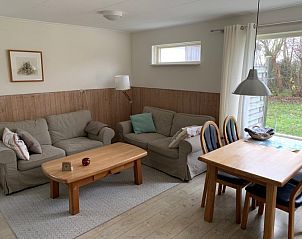 Gezellige woonkamer van Bungalow 0384 in De Koog, Texel, met comfortabele zitruimte en eetgedeelte voor familieplezier.