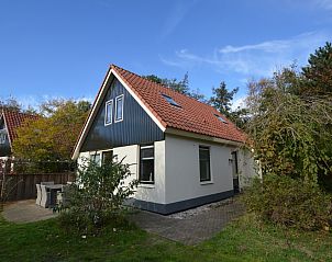 Das Ferienhaus 7G in De Koog, Texel, hat ein schnes ueres mit einem roten Dach und einer grnen Umgebung.