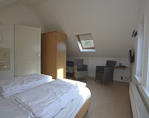 Mansardenzimmer im Ferienhaus 7G, De Koog, Texel mit Dachfenster und gemtlicher Sitzecke.