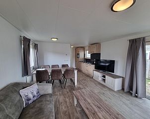 Modern ingerichte woonkamer van Chaletpark Bregkoog - Chalet 240 De Texelse Berg, De Koog, Texel met open keuken.