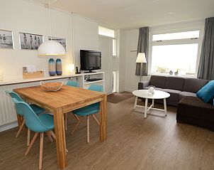Bright living room of Grand Hotel Opduin - Holiday home A, De Koog, Texel, with comfortable sofa and decorative lamp.