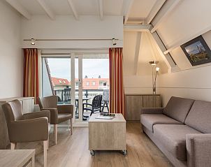 Gezellige woonkamer van C Appartement Comfort 4 in De Koog, Texel, met uitzicht op het terras en moderne inrichting.