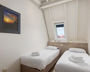 Geniet van het uitzicht op het zwembad en de groene omgeving vanaf het balkon van C Appartement Comfort 4 in De Koog, Texel.