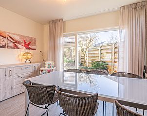 Eethoek in De Zandduyn vakantiehuis, De Koog, Texel, met stijlvolle meubels en uitzicht op de groene tuin.