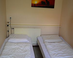 Slaapkamer met twee eenpersoonsbedden in Bungalow Faisca, De Koog, Texel, perfect voor een rustgevende nachtrust op de Waddeneilanden.