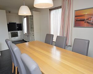 Stijlvolle eetkamer in Vakantiehuis Stappeland 171, De Koog, Texel met moderne keuken op de achtergrond.