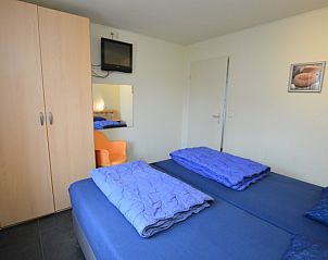 Slaapkamer in Vakantiehuis Stappeland 171, De Koog, Texel met kledingkast en televisie.