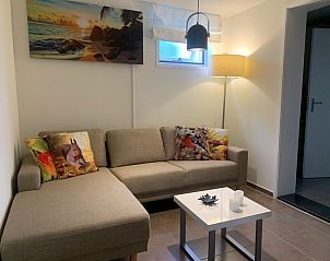 Stilvolles Wohnzimmer im Familienbungalow, De Koog, Texel mit farbenfrohen Kissen und modernen Mbeln.