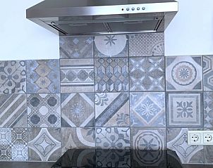 Detail von Kochfeld und Dunstabzugshaube im Familienbungalow, De Koog, Texel mit stilvollen Fliesen.