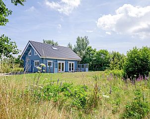 De Verleegen Hoek vakantiehuis in De Koog Texel, omringd door groene natuur en blauwe lucht.