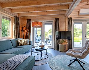 Comfortabele zithoek in De Verleegen Hoek vakantiehuis in De Koog Texel met uitzicht op terras.