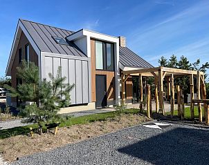 Duinvilla Wellness 6 in De Koog, Texel, ein modernes Ferienhaus mit Holzfassade und Veranda.