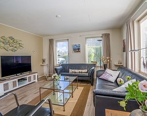 Gerumige Sitzecke im Ferienhaus Kamperfoelie 91, De Koog, Texel, mit modernen Mbeln und groen Fenstern.