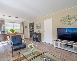 Stilvolles Wohn- und Esszimmer im Ferienhaus Kamperfoelie 91, De Koog, Texel, mit Holzboden und Fernseher.