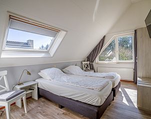 Schlafzimmer mit Dachfenster im Ferienhaus Kamperfoelie 91, De Koog, Texel, mit bequemem Doppelbett.