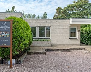 Ingang van Zilte Bries vakantiehuis in De Koog, Texel, met welkomsbord en groene omgeving.