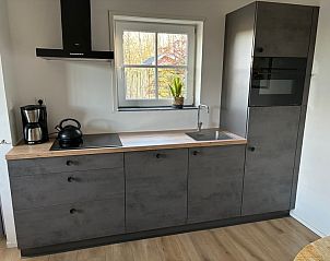 Kook met gemak in de moderne keuken van vakantiehuis Stormvogel in De Koog, Texel, voorzien van alle gemakken en een strak design.