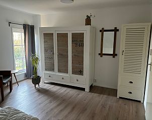 Stijlvolle slaapkameropslag in vakantiehuis Stormvogel in De Koog, Texel, met moderne kast en decoratieve accenten.