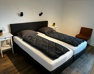 Comfortabele slaapkamer in Bungalow 2, De Koog, Texel met twee eenpersoonsbedden, ideaal vakantiehuis op de Waddeneilanden.