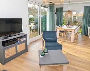 Ruime woonkamer van 't Mienthuis, vakantiewoning in De Koog, Texel, met comfortabele zithoek en tuinzicht.