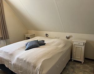 Hoofdslaapkamer in Koetshuis 3, vakantiehuis in De Koog, Texel, met ruim bed.
