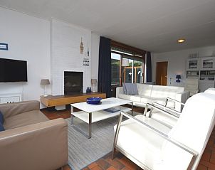 Gezellige woonkamer in Orchismient 18 groot, De Koog, Texel met moderne inrichting en open haard.