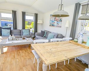 Gezellige woonkamer in Chalet Bregkoog 215 Zandhuisjes, Chaletpark Bregkoog, De Koog, Texel met comfortabele banken en houten vloer.