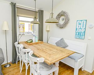 Eethoek in Chalet Bregkoog 215 Zandhuisjes, Chaletpark Bregkoog, De Koog, Texel met houten tafel en stijlvolle stoelen.