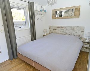 Slaapkamer met tweepersoonsbed in Chalet Bregkoog 215 Zandhuisjes, Chaletpark Bregkoog, De Koog, Texel biedt comfort en rust.