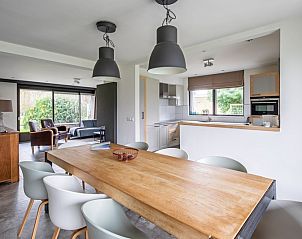 Essecke in Orchismient 20 Ferienhaus De Koog Texel mit groem Tisch und modernen Sthlen.