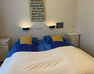 Comfortable bedroom in Landgoed Springtij - Koetshuis 1, De Koog, Texel, with double bed and atmospheric lighting.