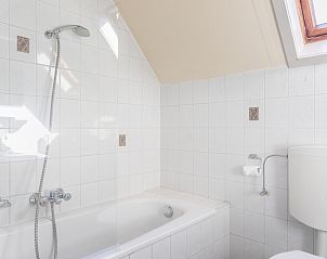 Bright bathroom in Landgoed Springtij - Koetshuis 1, De Koog, Texel, with bathtub and skylight for natural light.