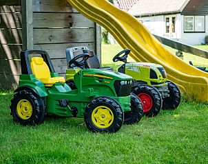Child-friendly play area on Springtij Estate - Koetshuis 1, De Koog, Texel, with toy tractors and green surroundings.