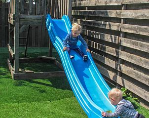 Glijbaan in de speeltuin van 't Langebosch vakantiehuis, Dennenbos, Texel voor kinderen om te genieten op de Waddeneilanden.