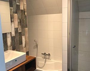 Moderne badkamer met ligbad in Nieuwlanderweg 75 vakantiehuis, De Koog, Texel, perfect voor ontspanning na een dag op het strand.