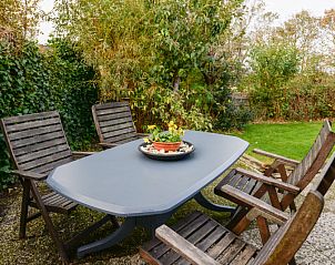Buiten terras met houten stoelen in De Kikker, vakantiehuis in Den Burg, Texel.