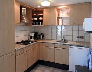 Volledig uitgeruste keuken in Bungalow 0983, Den Burg Texel, vakantiehuis met moderne apparatuur en houten kasten.