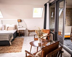 Sfeervolle zithoek Nobel Hotel, Ballum, Ameland, vakantie appartement met comfortabele stoelen en decoratieve elementen.