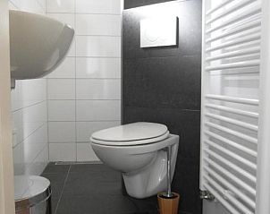 Moderne badkamer in Zeealsem vakantiehuis, Ballum, Ameland, met toilet en wastafel.