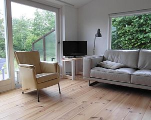 Gezellige woonkamer in Zeealsem vakantiehuis, Ballum, Ameland met uitzicht op de tuin.