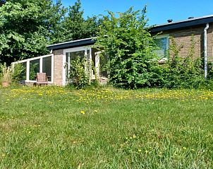 Zeealsem vakantiehuis in Ballum, Ameland, omgeven door bloemen en groen.