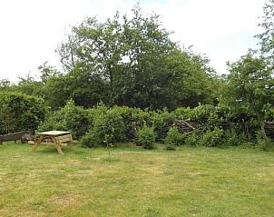 Ruime tuin van Zeealsem vakantiehuis in Ballum, Ameland met picknicktafel.