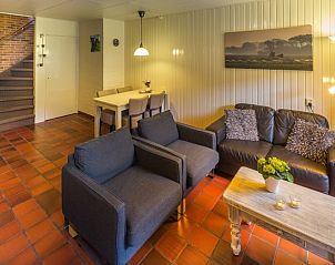 Gezellige woonkamer van Appartement De Merel, Den Burg, Texel, met comfortabele banken en warme inrichting.