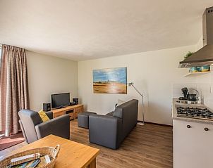 Ruime binnenruimte van Slingerhuusie vakantiehuis in Den Burg, Texel met uitzicht op de tuin en een gezellige zithoek.