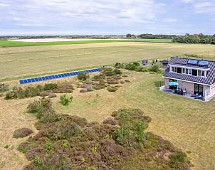 Luchtfoto van Vakantiehuisje in Den Burg met uitgestrekte velden op Texel, Waddeneilanden.