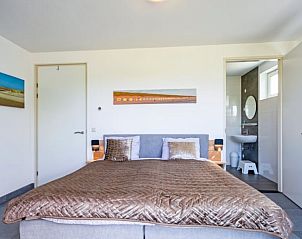 Ruime slaapkamer met ensuite badkamer in Vakantiehuisje in Den Burg, Texel, Waddeneilanden.