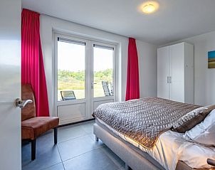 Slaapkamer met uitzicht op de tuin in Vakantiehuisje in Den Burg, Texel, Waddeneilanden.